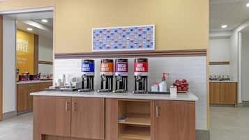 A coffee station with four dispensers labeled DARK ROAST, LIGHT ROAST, DECAF ROAST, and HOT WATER.