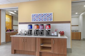 A coffee station with four dispensers labeled DARK ROAST, LIGHT ROAST, DECAF ROAST, and HOT WATER.