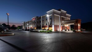 A hotel with a modern design, featuring a central entrance, multiple parking spaces, and a well-lit facade. - Hampton Inn Pine Grove (Pine Grove)