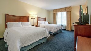 A hotel room with two beds, a desk, a television, and a window with curtains. - Hampton Inn Pine Grove (Pine Grove)