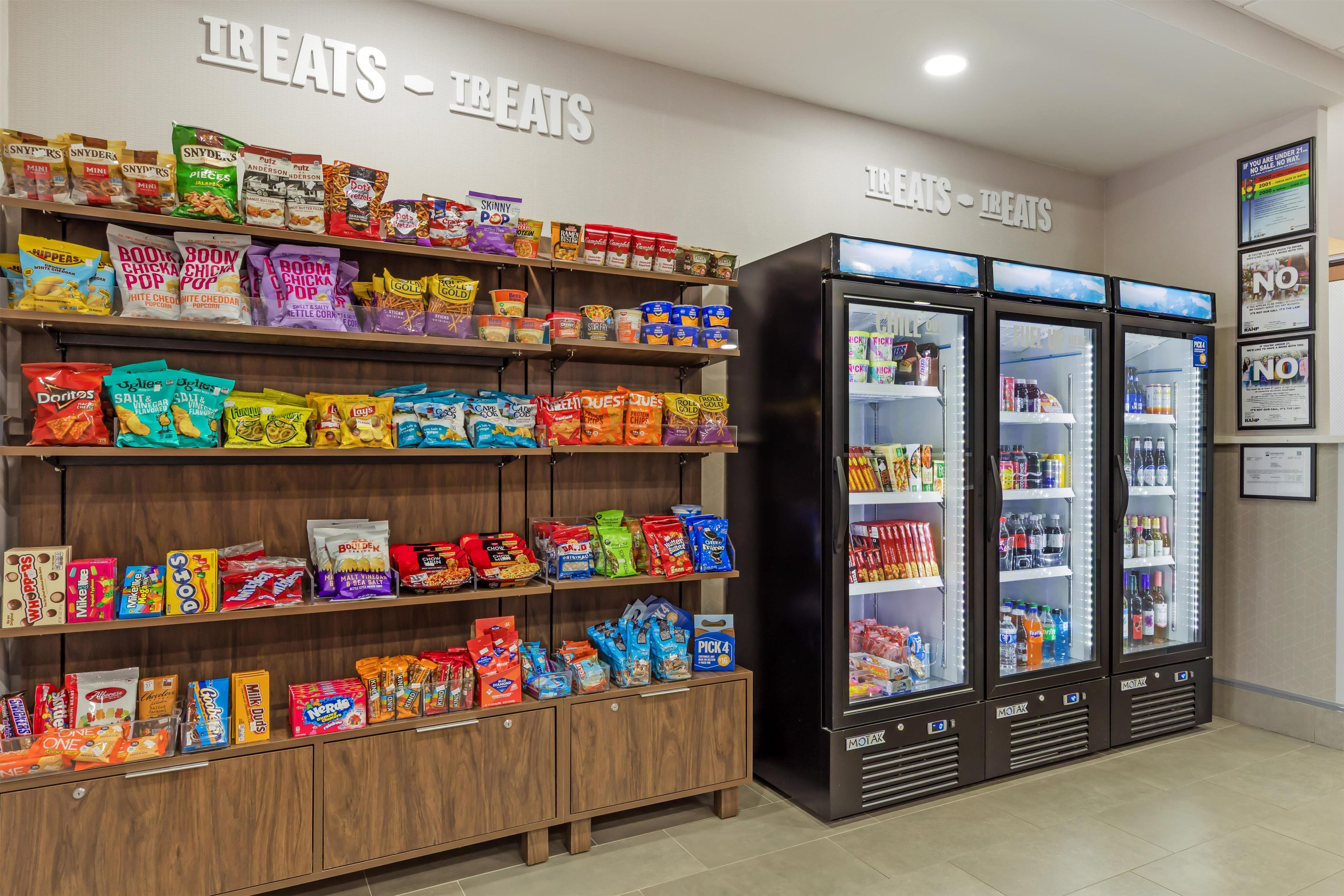 A snack display with various brands and a refrigerated beverage area.