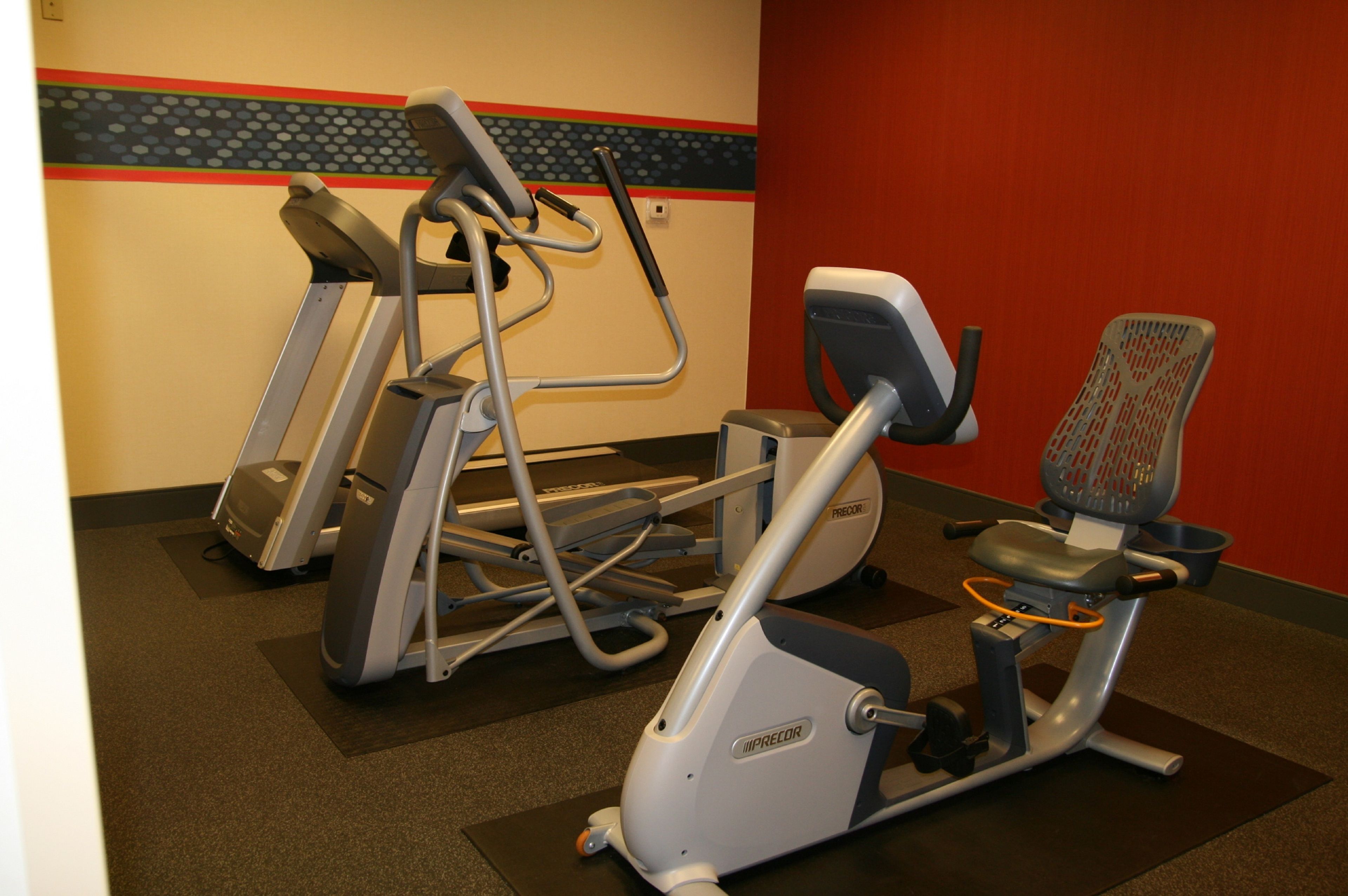 A gym with treadmills, an elliptical, and a stationary bike.