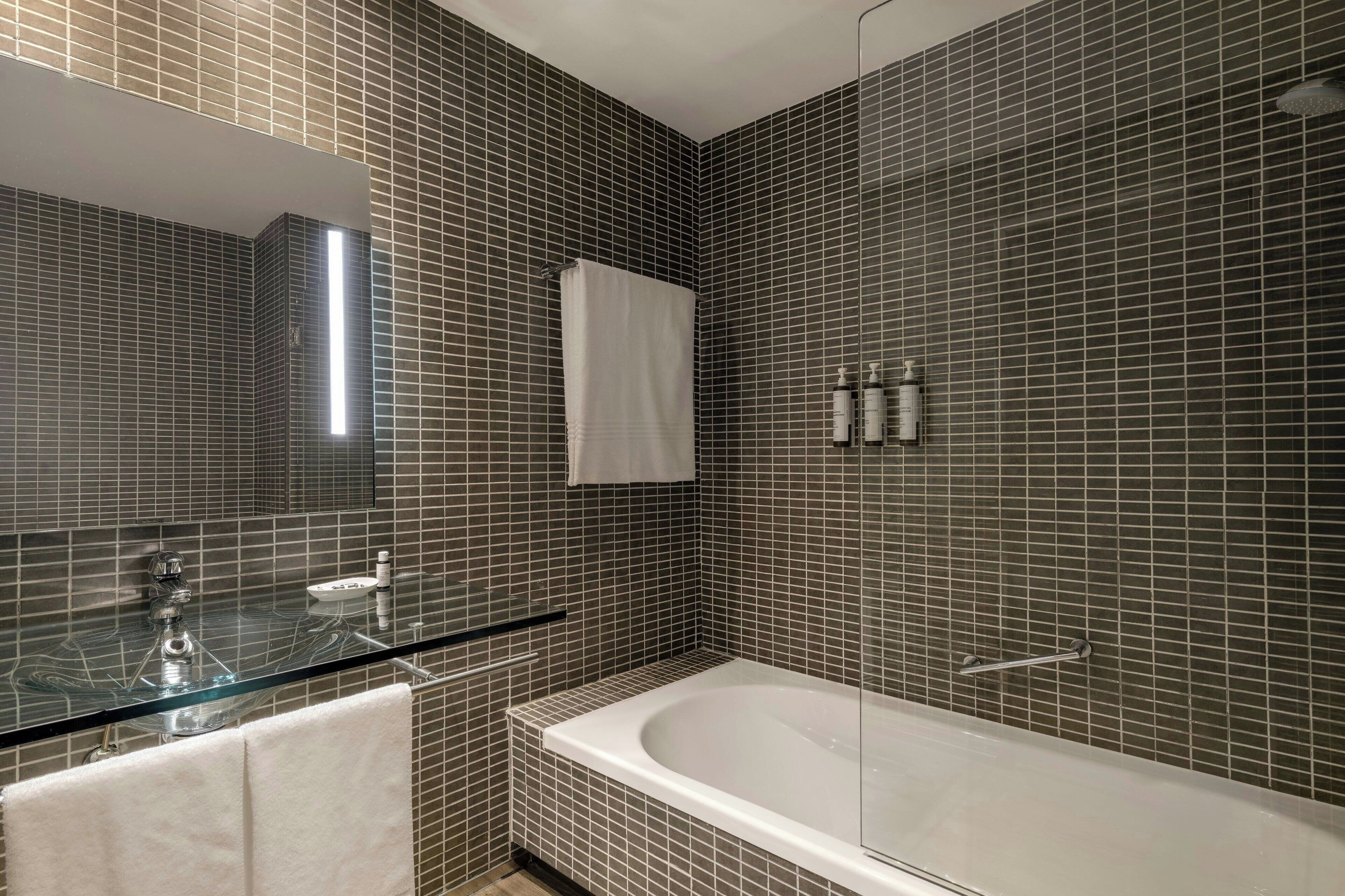 combined shower/bathtub, designer toiletries, hair dryer, slippers