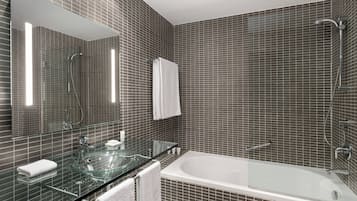 Une salle de bain moderne avec un lavabo intégré dans une structure en verre, une grande baignoire et un espace douche.