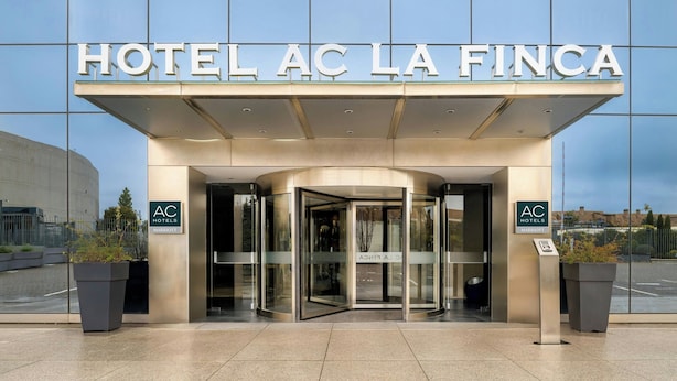 The entrance of Hotel AC La Finca with a revolving door and glass facade. - AC Hotel La Finca by Marriott (Pozuelo de Alarcon)