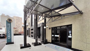 A hotel entrance with a glass canopy, a sign for Granville Park Hotel, and a tiled floor. - Granville Hotel (Curitiba)