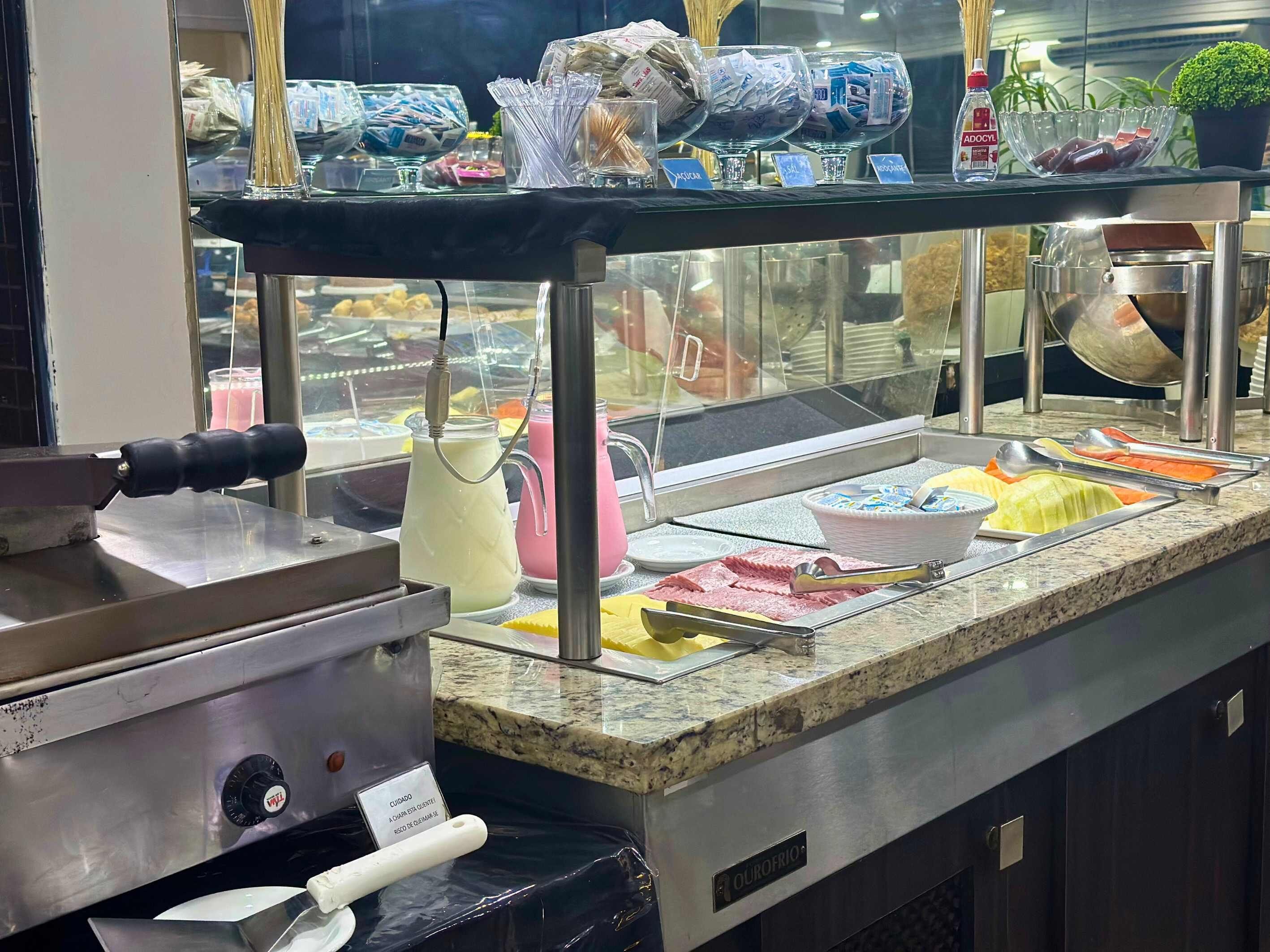 A buffet area with various food items and a beverage dispenser.