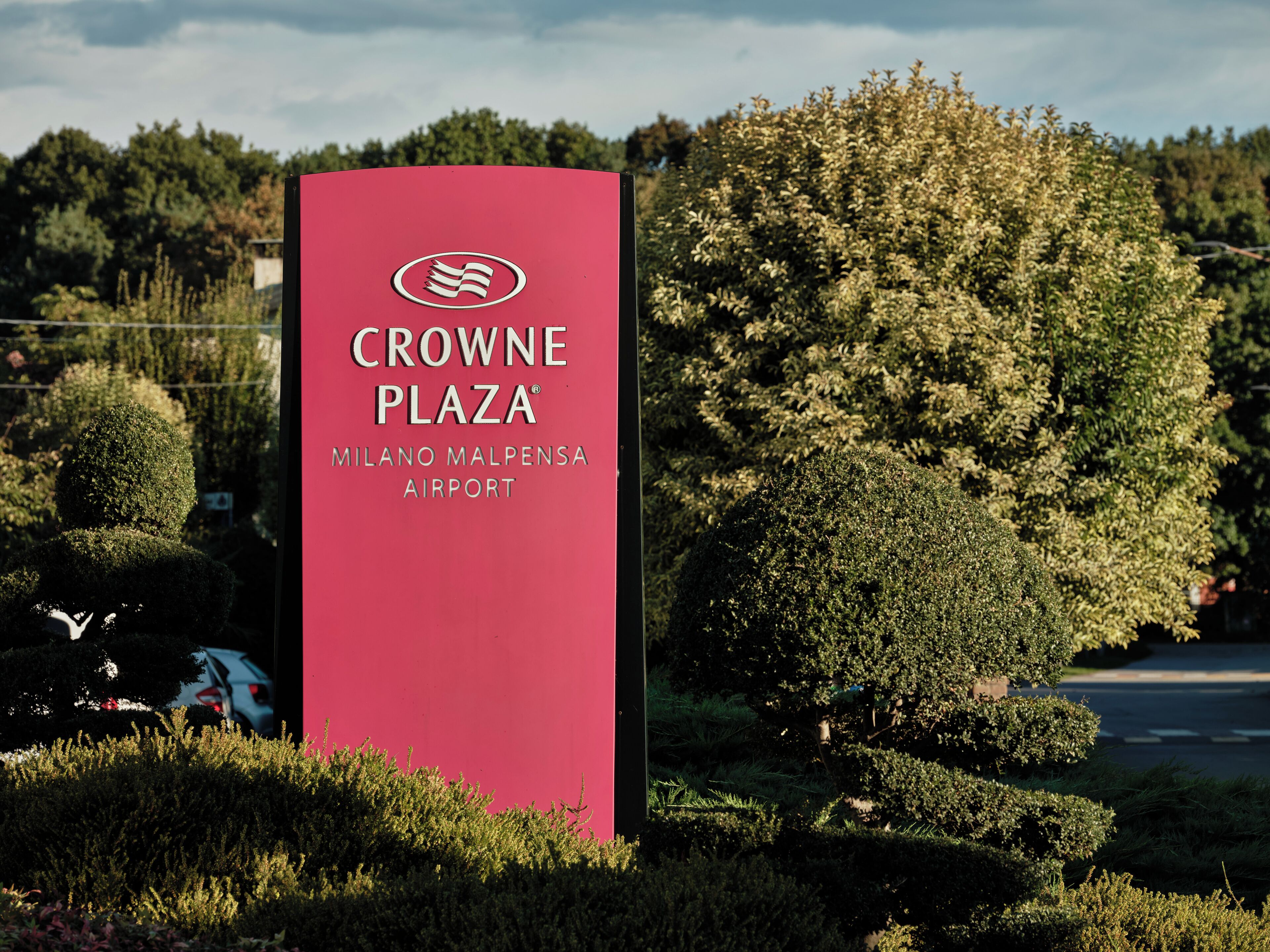 A red sign for Crowne Plaza Milano Malpensa Airport.