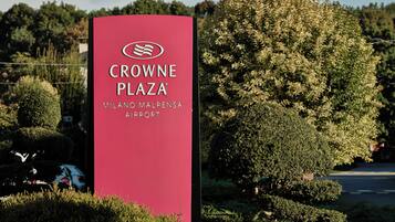 A red sign for Crowne Plaza Milano Malpensa Airport.