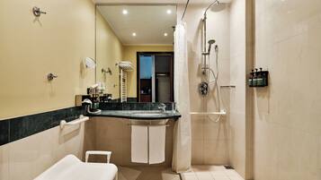 Een moderne badkamer met douche, toilet en wastafel, inclusief handdoekhouder.