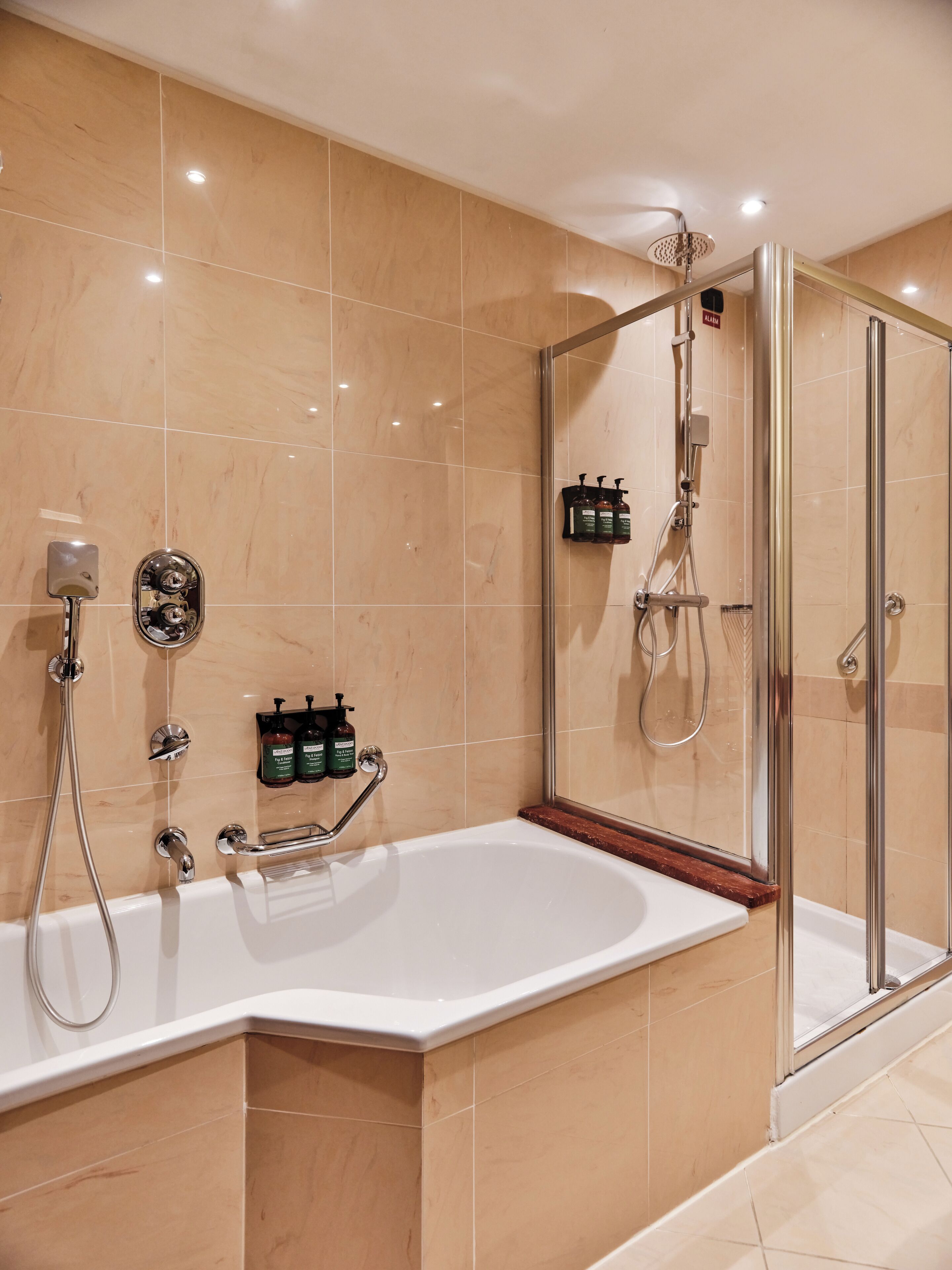 Ein modernes Badezimmer mit einer großen Badewanne, einer Duschkabine und einem Waschtisch mit Spiegel.