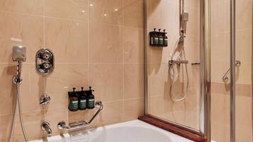 Ein modernes Badezimmer mit einer großen Badewanne, einer Duschkabine und einem Waschtisch mit Spiegel.