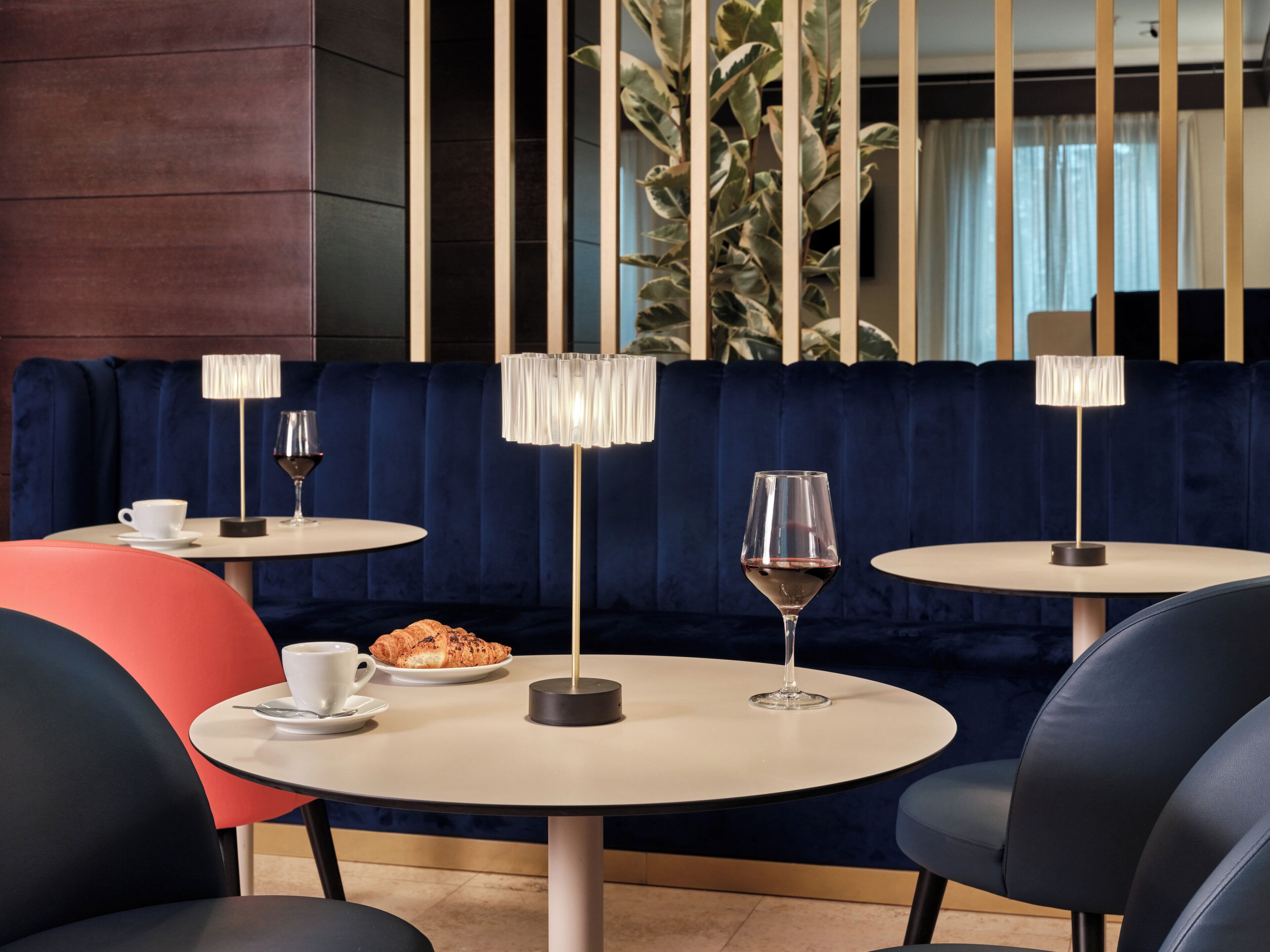 A restaurant interior with round tables, chairs, and a blue upholstered booth.