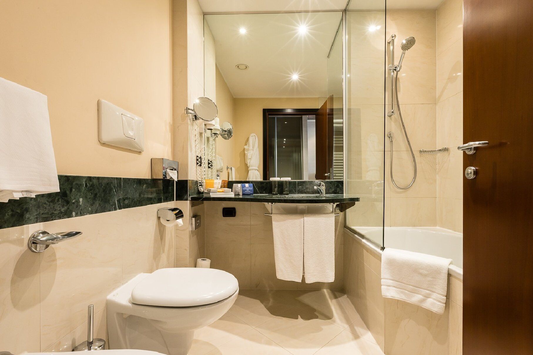 Une petite salle de bain comprenant des toilettes, un lavabo et une douche.