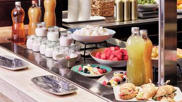 A buffet table with various food items and beverages.
