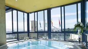 A hot tub with a view of flags and a cityscape. - MS Maestranza Málaga Centro (Málaga)