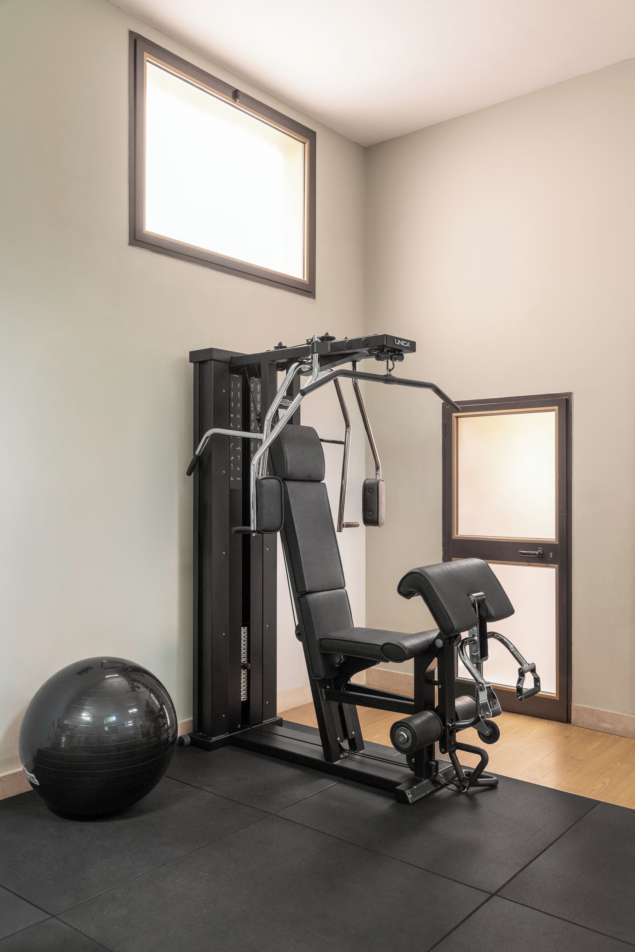 Una palestra con una sbarra per trazioni, una panca e una palla medica.