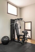 A gym with a pull-up bar, a bench, and a medicine ball.
