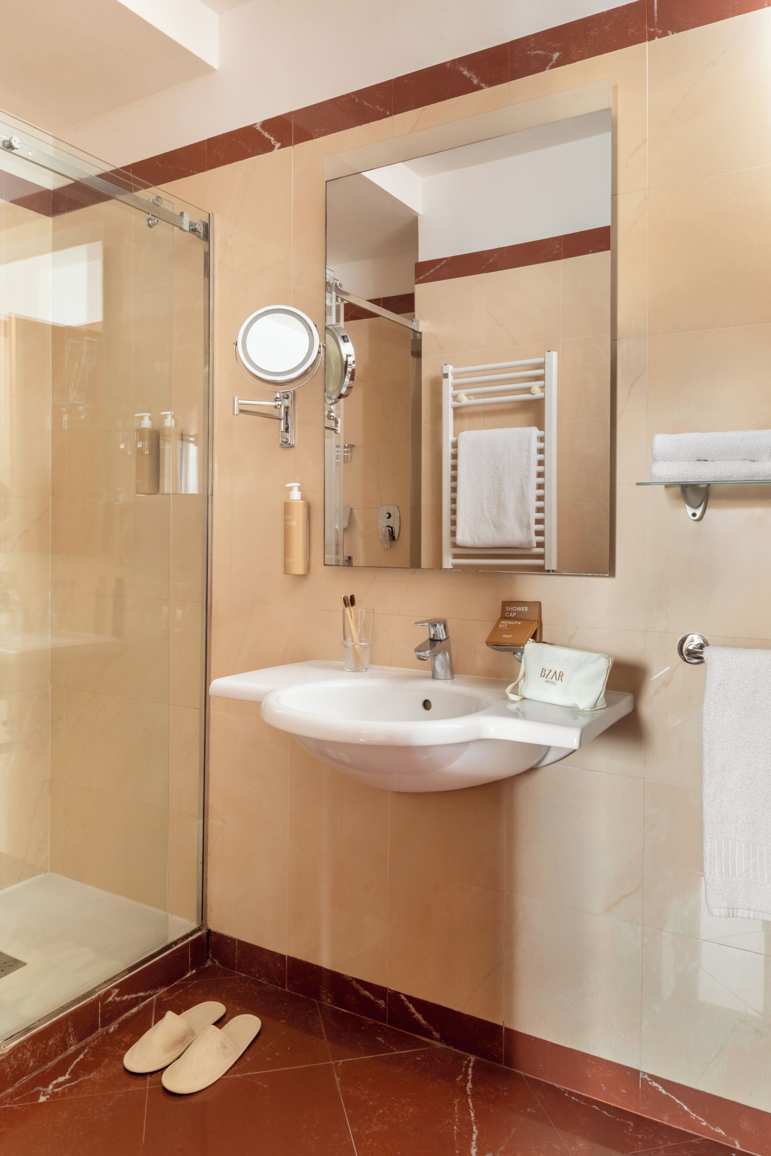 Un bagno con box doccia in vetro, un lavandino con specchio e un porta asciugamani.