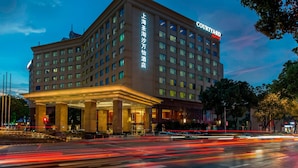 A Courtyard hotel with a prominent entrance and signage in a foreign language. - Courtyard by Marriott Shanghai Fengxian (Shanghai)