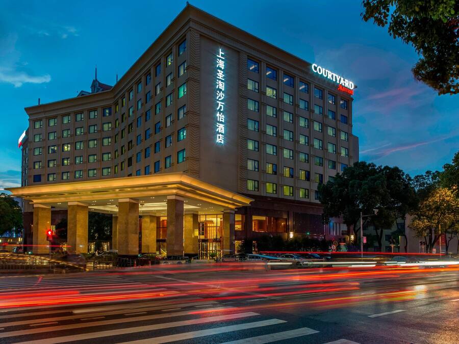 Un hotel Courtyard con una entrada destacada y señalización en un idioma extranjero.
