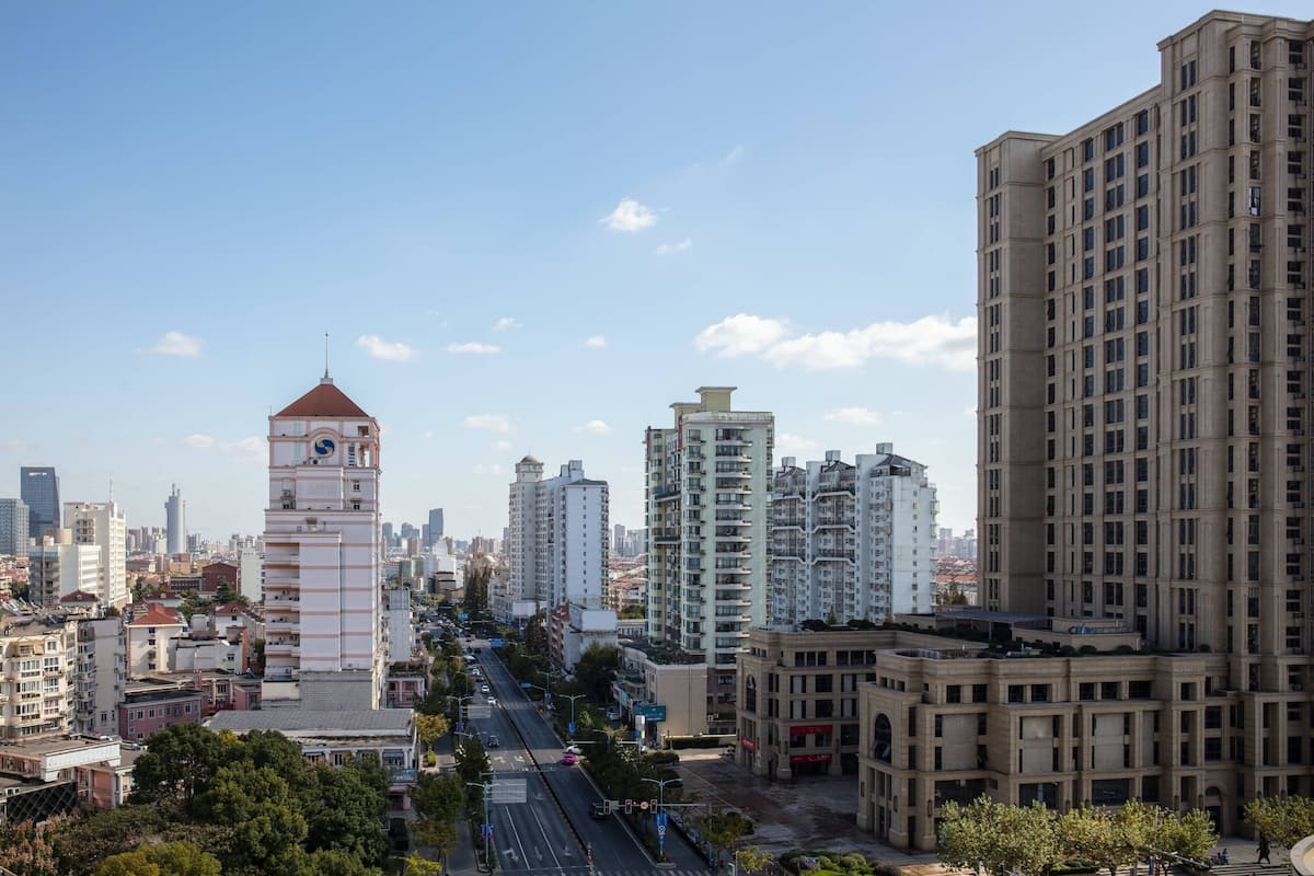A cityscape with a prominent clock tower, high-rise buildings, and a clear sky.