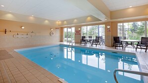 Ein Hallenbad mit deutlicher Beschilderung, darunter ein Schild mit der Aufschrift 'No Diving', und einem Sitzbereich mit Tischen und Stühlen.