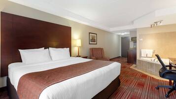 A hotel room with a large bed, a desk, a chair, a bathroom with a bathtub, and a shower.
