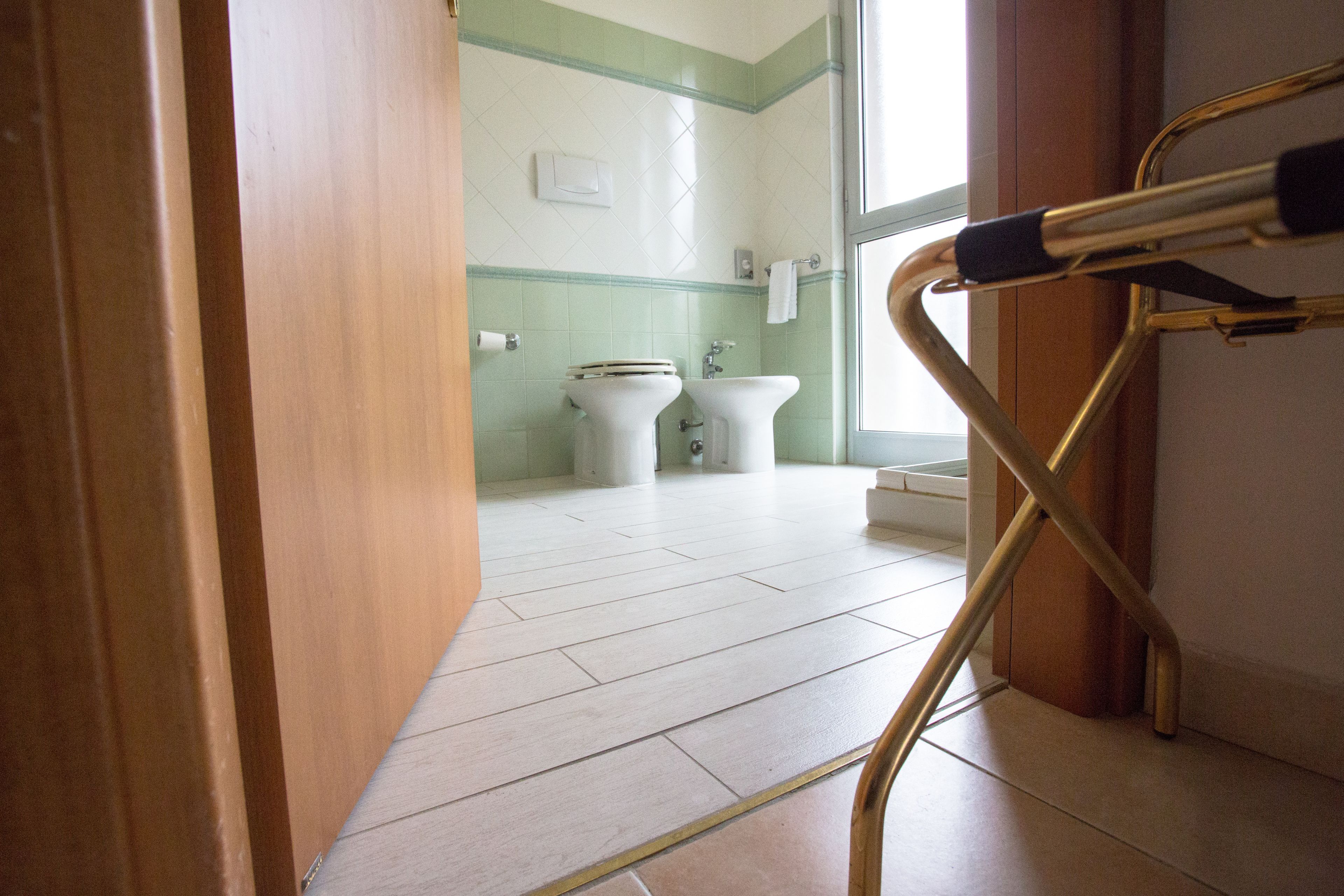A bathroom with a toilet, bidet, and sink.