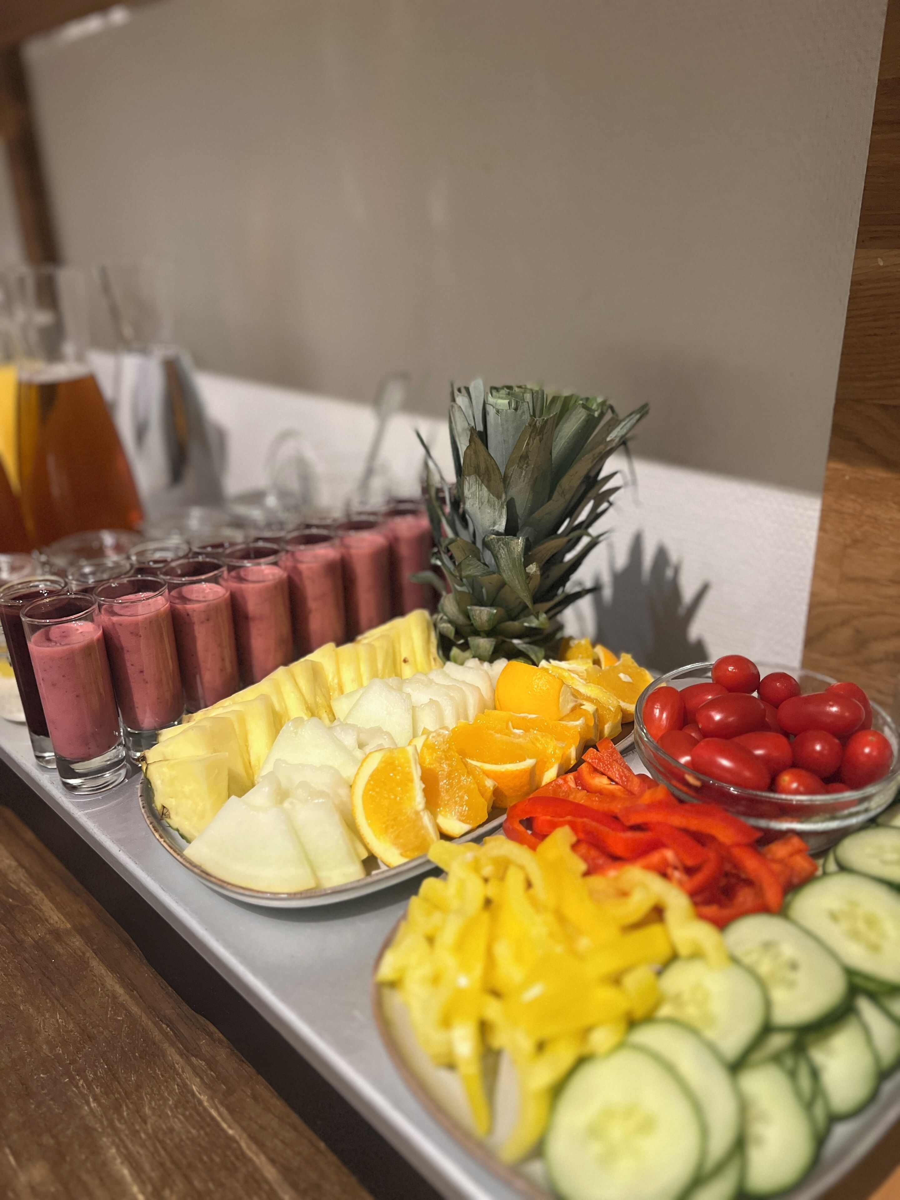 Una bandeja con frutas variadas y un vaso de jugo.