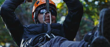 A person in a harness and helmet, indicating a focus on safety and adventure activities.
