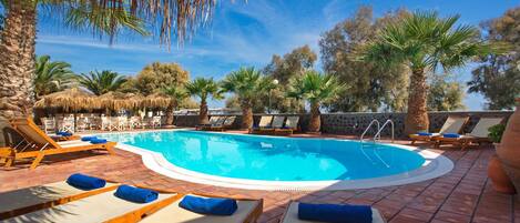 Familie vierpersoonskamer | Zwembad | Een buitenzwembad, parasols bij het zwembad en ligstoelen