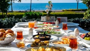 A table set for breakfast with various dishes, drinks, and a view of the sea. - Kalyon Hotel Istanbul (Istanbul)