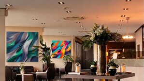 A modern lobby with a central seating area, large abstract paintings, and multiple potted plants. - Kalyon Hotel Istanbul (Istanbul)