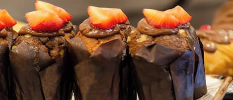 Eine Dessertplatte mit schokoladenüberzogenen Gebäckstücken, belegt mit Erdbeeren.