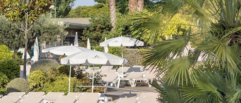 Piscine couverte, piscine extérieure, parasols de plage, chaises longues