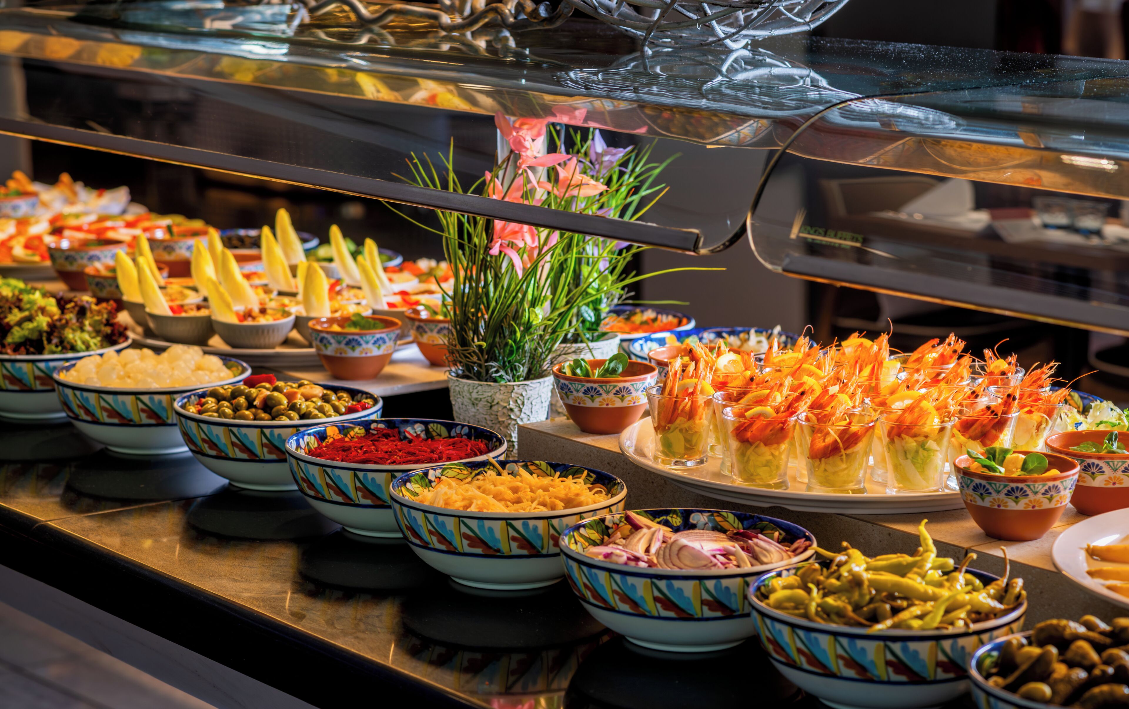 A buffet with various dishes and a decorative plant.