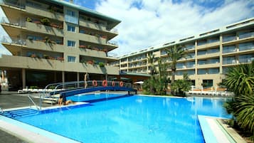 Relax by the pool surrounded by lush greenery and comfortable lounge chairs.