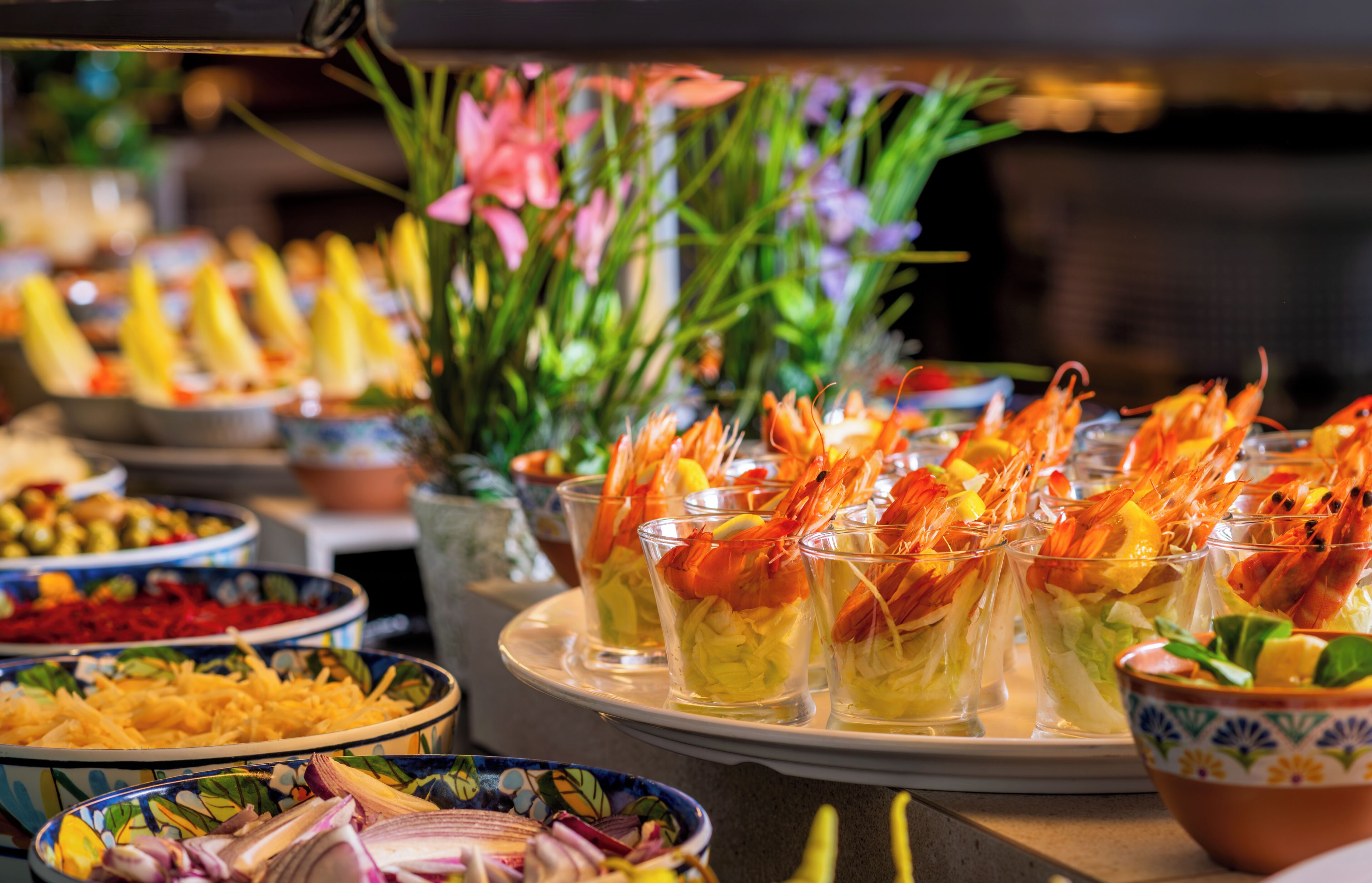 A buffet with various dishes, including shrimp cocktails and salads.