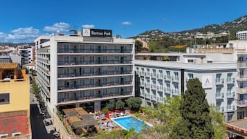 Experience the Betran Park's modern architecture and unwind by the pool with lounge chairs and umbrellas.
