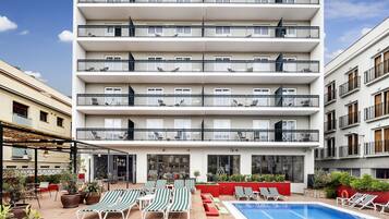 Een buitenzwembad, ligstoelen bij het zwembad