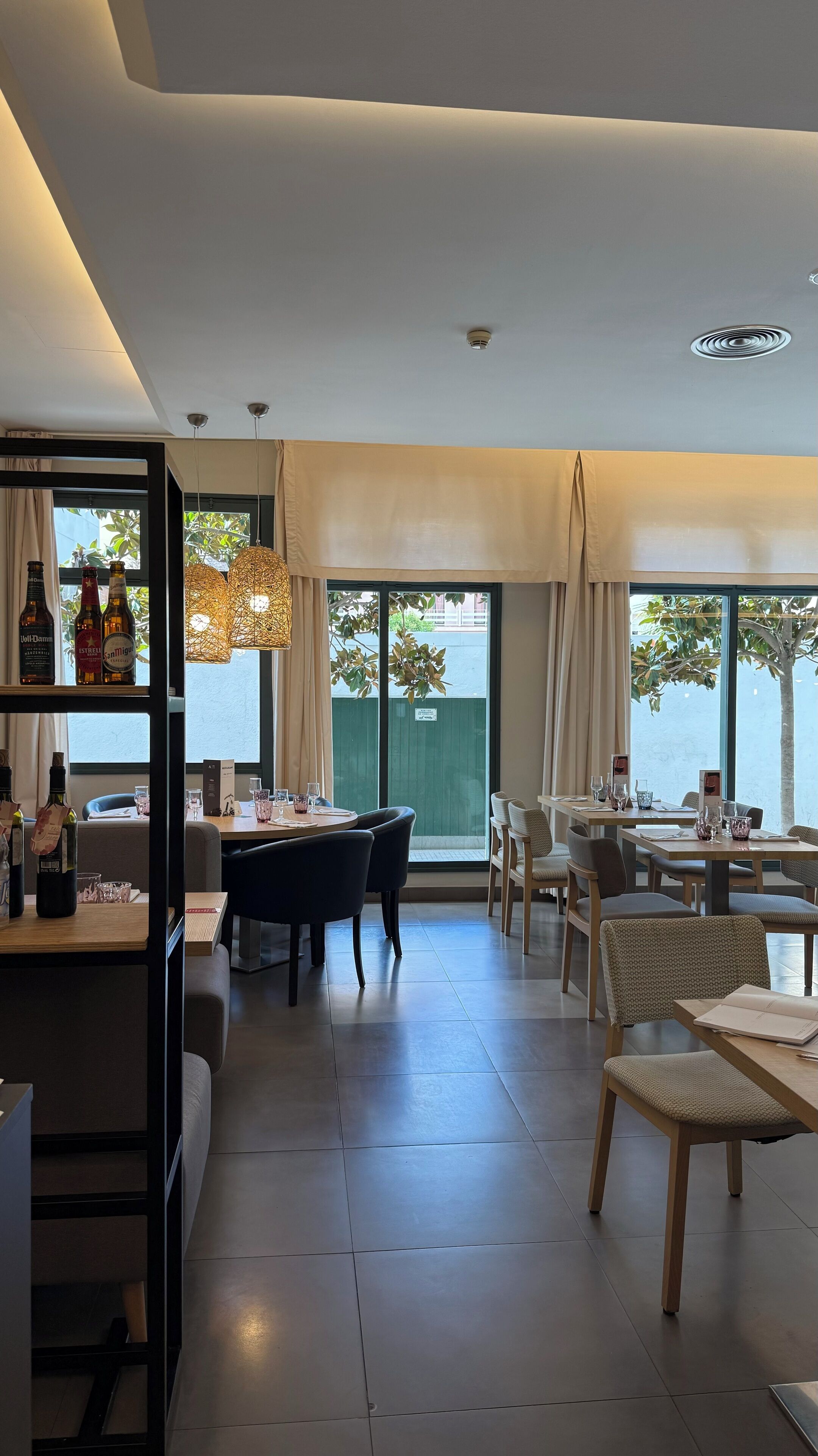 Un comedor moderno con barra, varias mesas y sillas.