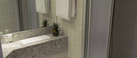 A bathroom with a toilet, sink, and shower.
