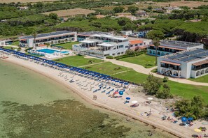 Privat strand, hvit sand, solsenger og parasoller