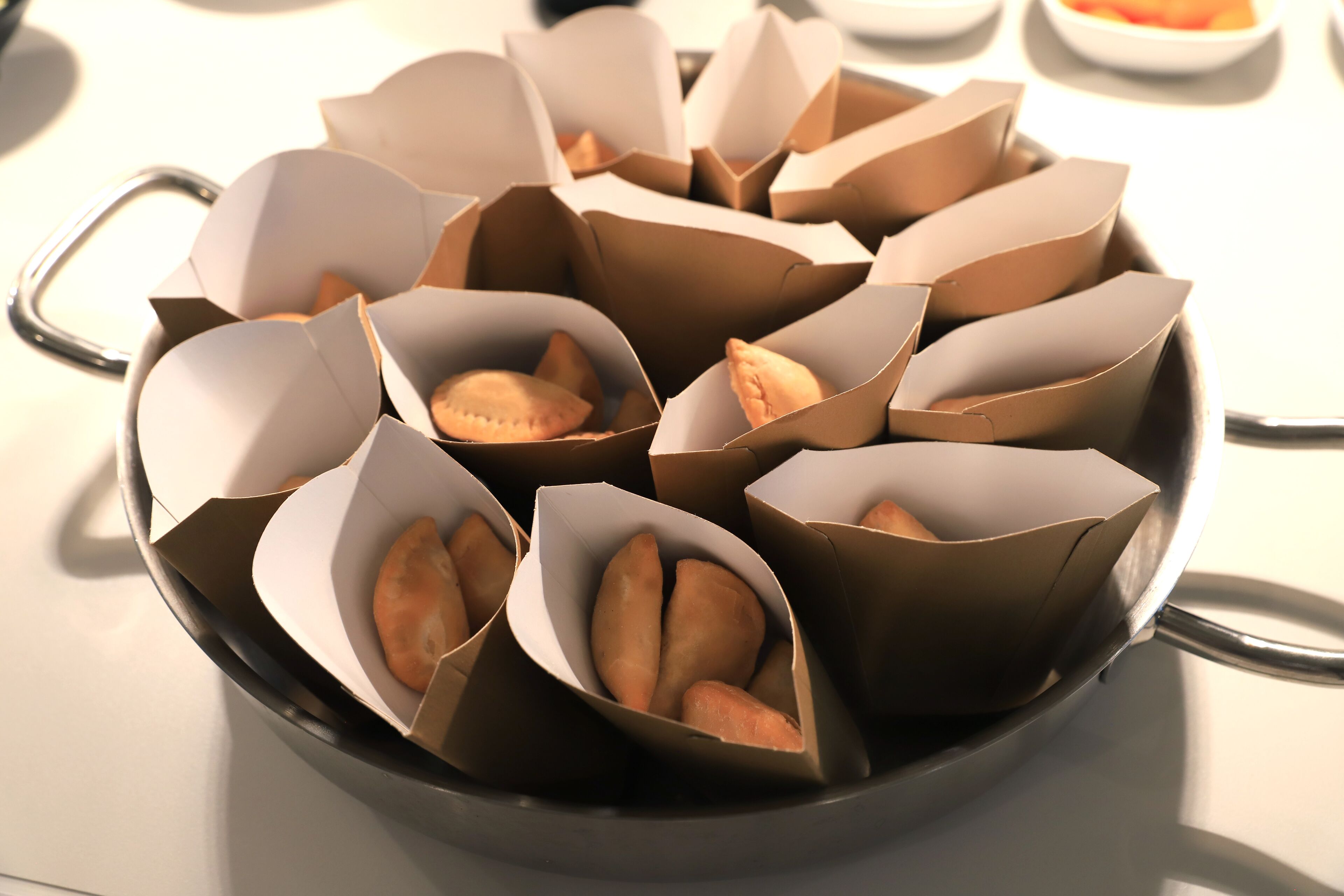 Een pan vol gebakjes in papieren bakjes.