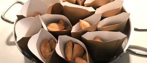 A pan filled with pastries in paper containers.