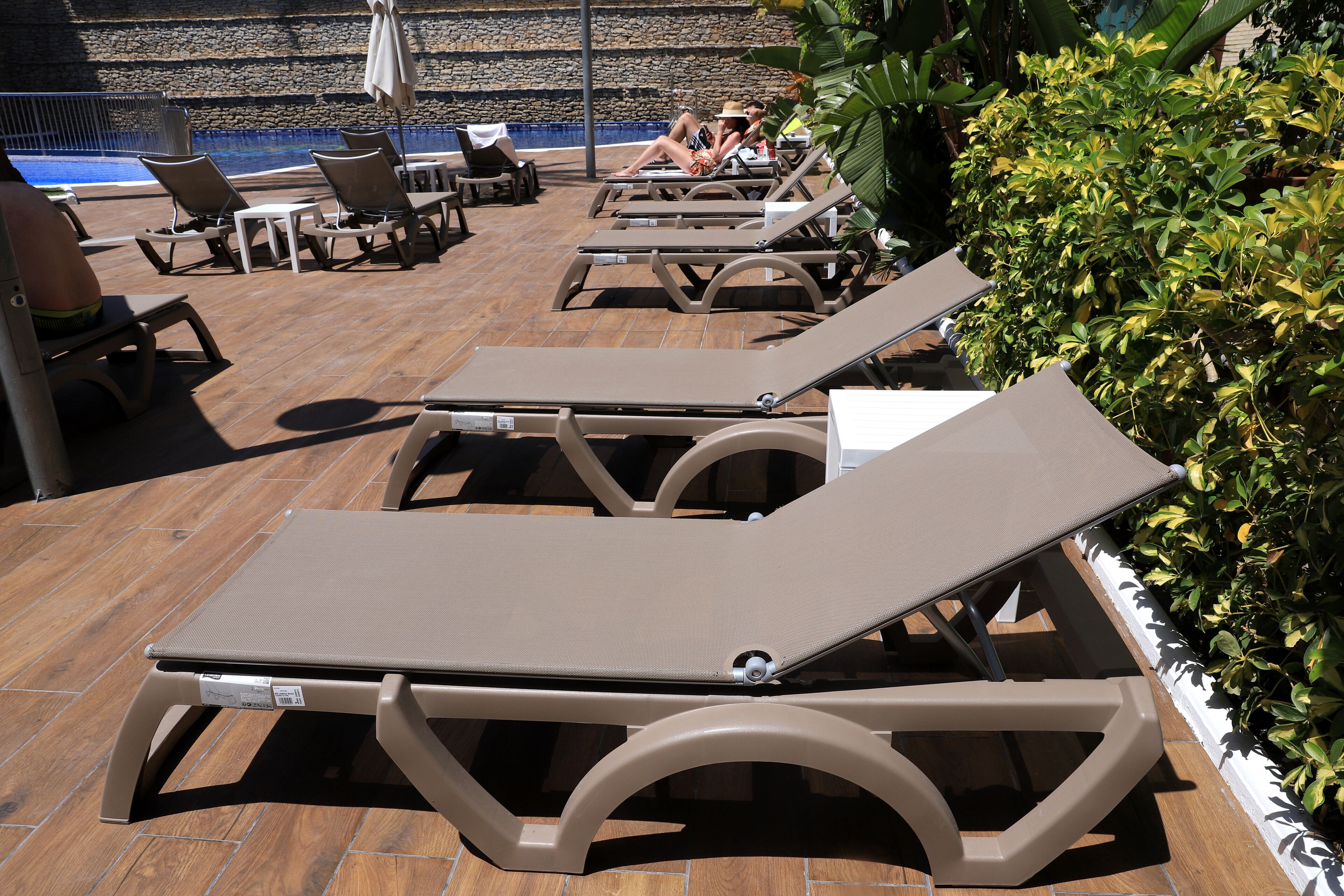 A poolside area with lounge chairs and a small table.