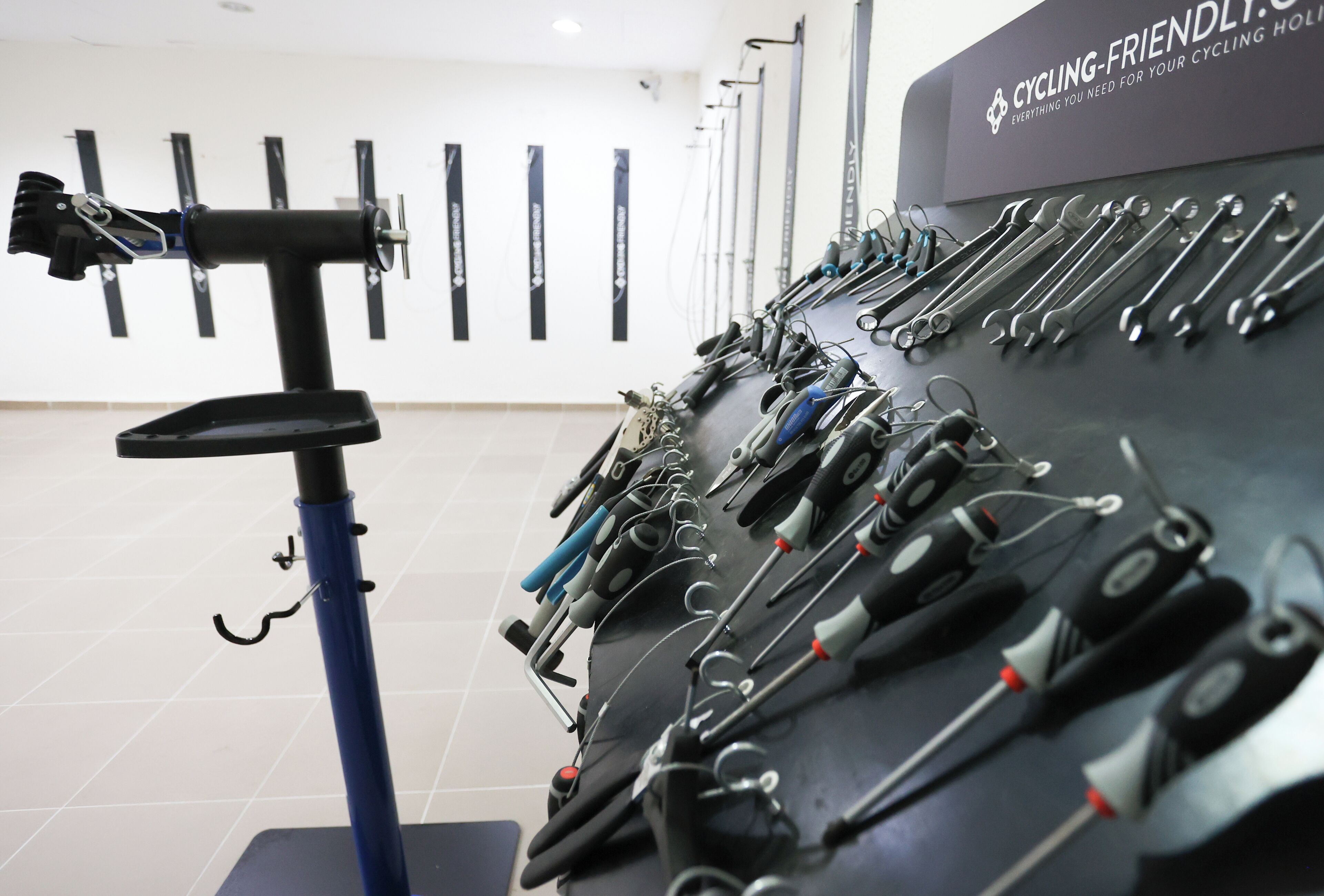 A wall-mounted tool rack with various cycling tools.