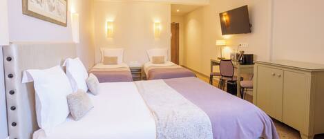 Une chambre d’hôtel avec un grand lit, un bureau, une chaise, une télévision et une armoire.