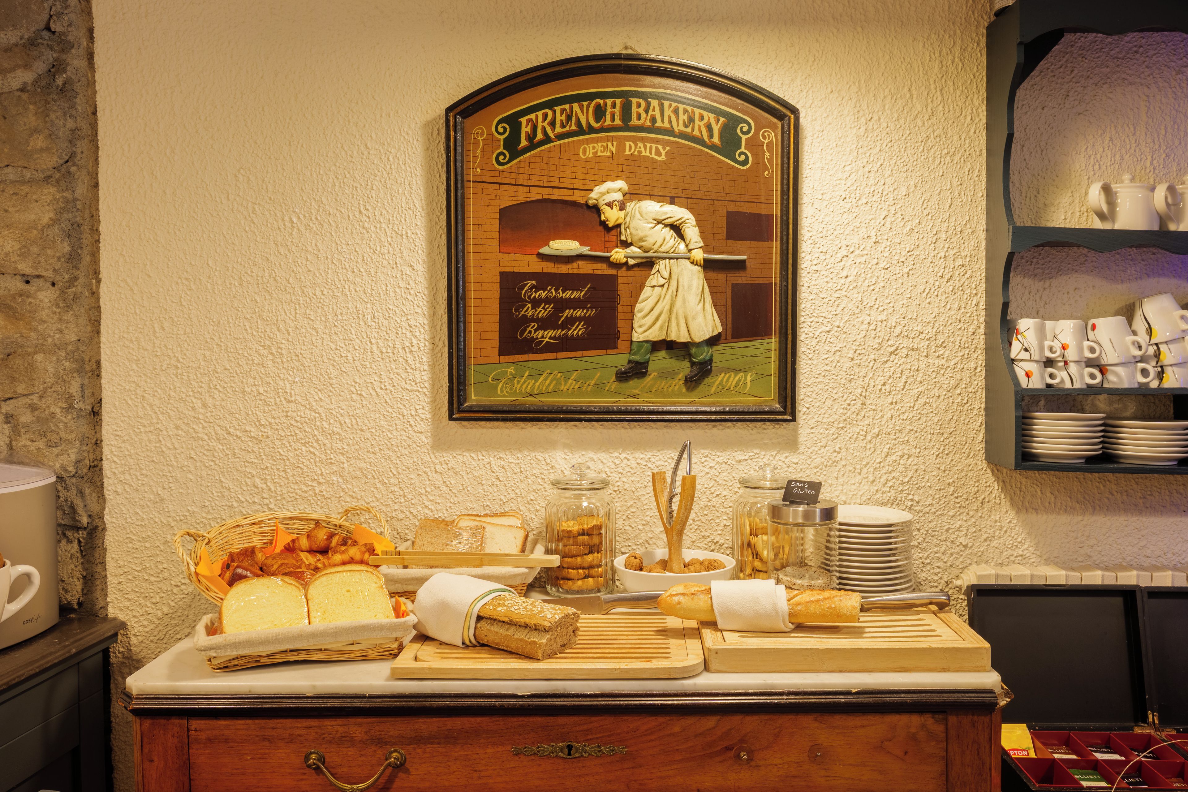 Letrero de una panadería francesa con exhibición de pan y una estación de café.